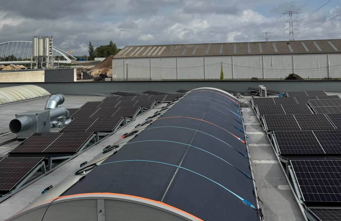Vue rapproch&eacute;e de modules solaires flexibles &eacute;pousant la courbure du toit, c&acirc;bles MC4 de part et d'autre