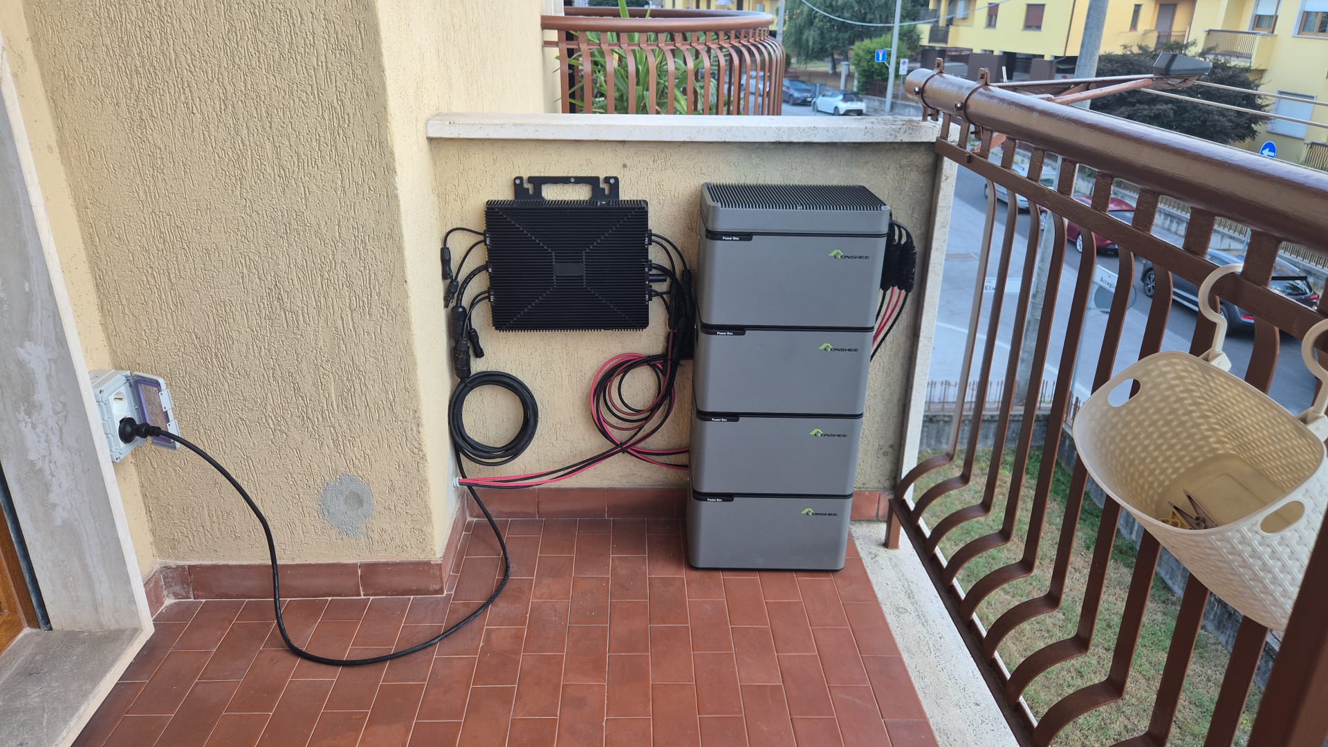 Balcon d'appartement italien avec quatre modules de batterie LIONSHEE empil&eacute;s, unit&eacute; murale et c&acirc;ble vers une prise domestique